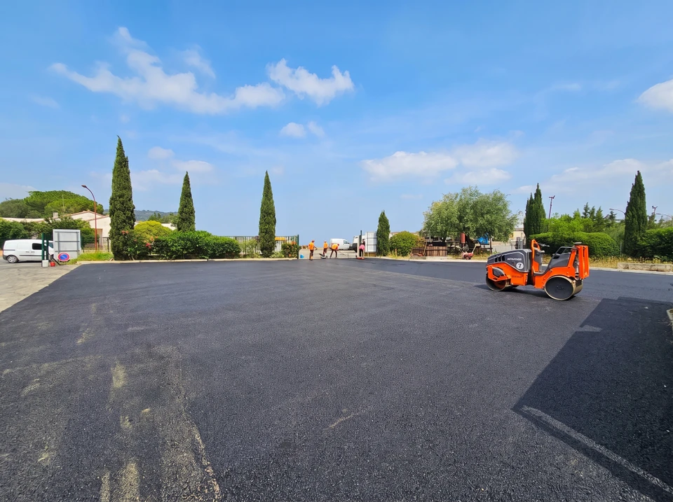 Chantier de revêtement bitumineux en extérieur, enrobé noir fraîchement posé sur une grande surface