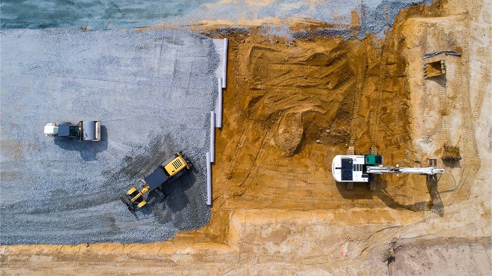 Parking récemment asphalté avec un arbre isolé sur îlot béton central