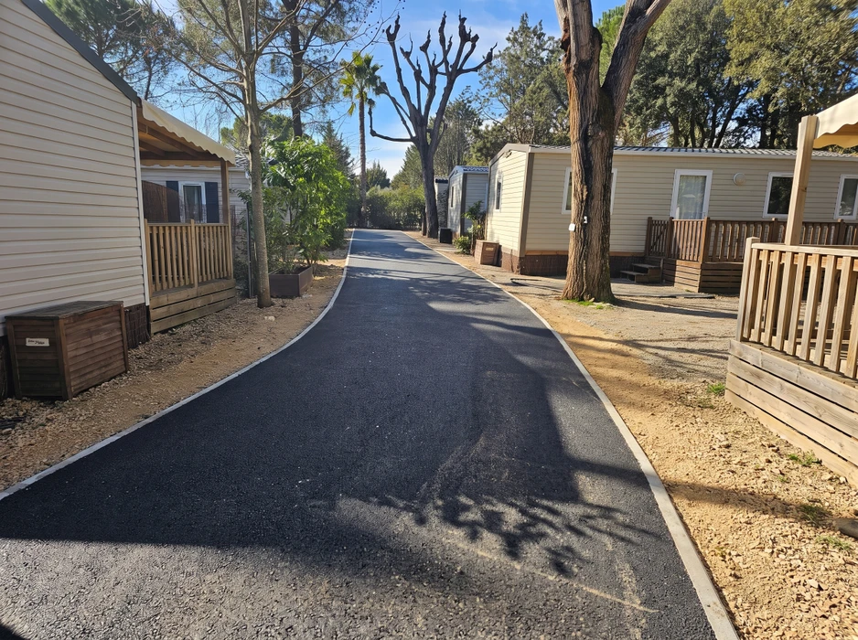 Deux ouvriers en combinaisons orange haute visibilité réalisent des travaux d'enrobé bitumineux