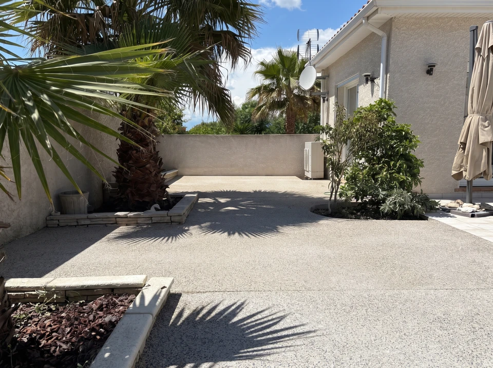 Façade résidentielle avec allée pavée en pierre naturelle menant à garage double