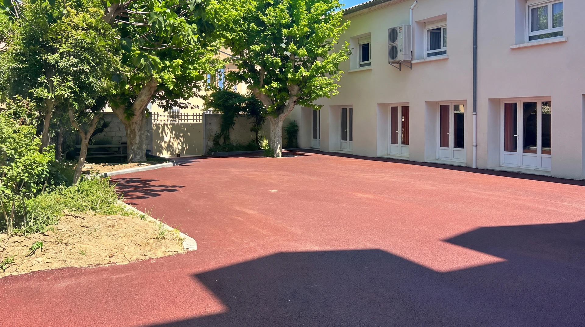 Parking neuf avec marquage au sol blanc fraîchement peint : places de stationnement, flèches directionnelles et passage piéton zébré