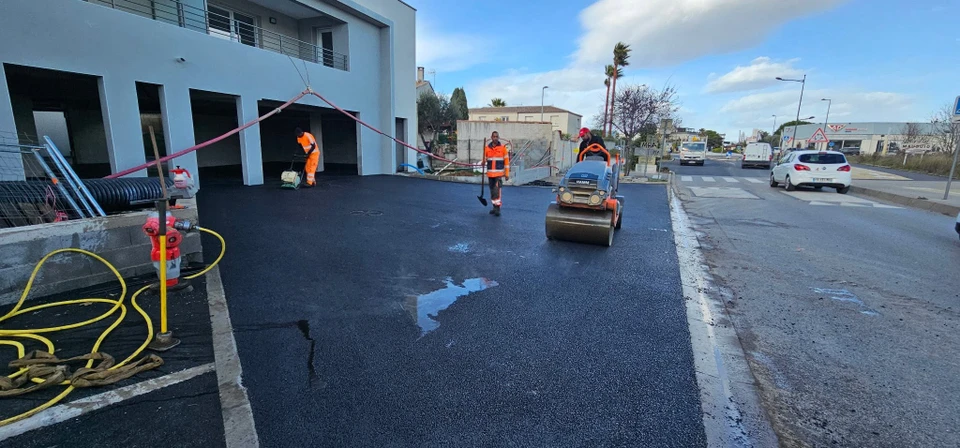 Chantier de revêtement bitumineux en extérieur, enrobé noir fraîchement posé sur une grande surface